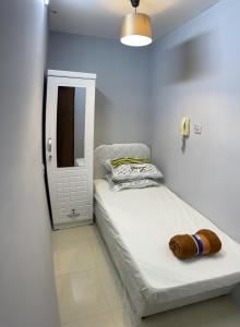 a small bedroom with a bed and a mirror at Pharaohs Inn MOE Hostel in Dubai