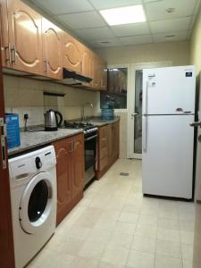 cocina con nevera y lavadora en Pharaohs Inn MOE Hostel en Dubái