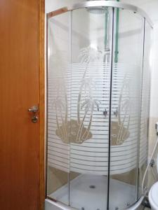 a shower with a glass door with a plant on it at Pharaohs Inn MOE Hostel in Dubai