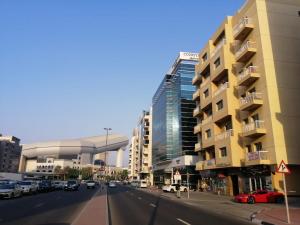 una calle de la ciudad con coches estacionados frente a los edificios en Pharaohs Inn MOE Hostel en Dubái