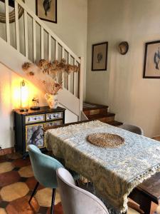 een eetkamer met een tafel en stoelen en een trap bij Le Domaine de Camblanes in Camblanes-et-Meynac