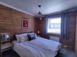 Mefjordvær的住宿－Norwegian house Maria Stua，一间卧室设有一张大床和一个窗户。