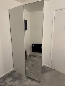 a room with a mirror and a television in it at Lovely Modern One bedroom Flat close to station in Belvedere
