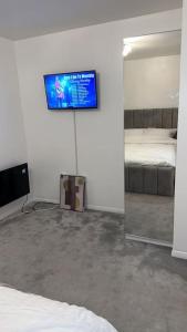 a bedroom with a mirror and a tv on the wall at Lovely Modern One bedroom Flat close to station in Belvedere