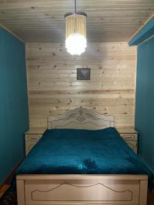 una camera da letto con un letto con una parete in legno di Guest House Latali a Mestia