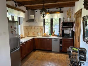 a kitchen with wooden cabinets and stainless steel appliances at Dom w Gruszkach - Puszcza Białowieska in Narewka