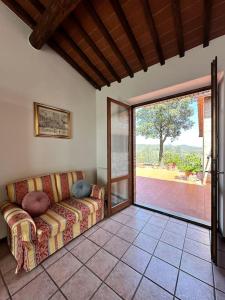 Una sala de estar con un sofá y una puerta corrediza de vidrio. en Casa il Cipresso, en Castelnuovo Berardenga