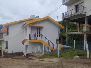 um edifício branco com uma escada amarela em Seven Endue Elite em Ooty