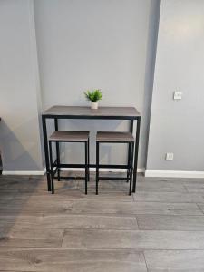 uma mesa com duas cadeiras e uma planta sobre ela em One Bedroom flat sittingbourne em Kent