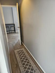 un pasillo con una puerta que conduce a una habitación con alfombra en One Bedroom flat sittingbourne, en Kent