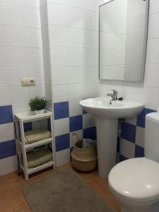 a bathroom with a sink and a toilet and a mirror at Apartamento en El Médano con piscina y garaje in El Médano