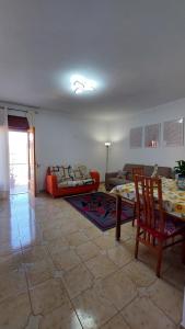 un soggiorno con tavolo e divano di La Casa Sicula a Capri Leone