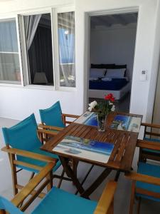 a dining room with a wooden table and chairs at Blue Waves Suite Mykonos in Kalafatis