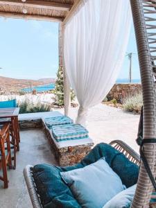 a patio with a couch and a table with a view at Blue Waves Suite Mykonos in Kalafatis