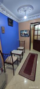 a living room with two chairs and a blue wall at Casa Lotfi in Chefchaouene