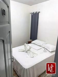 Kleines Zimmer mit 2 Betten und weißer Bettwäsche in der Unterkunft Hotel Central Abaetetuba in Abaetetuba