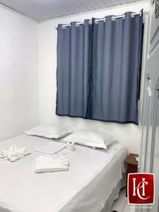 Zimmer mit einem Bett und einem blauen Vorhang in der Unterkunft Hotel Central Abaetetuba in Abaetetuba