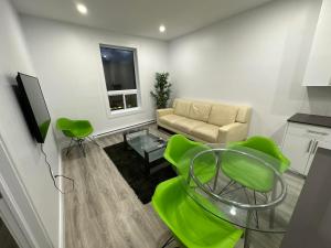 蒙特婁的住宿－Appartement 2 chambres - 202，客厅配有沙发、桌子和绿色椅子