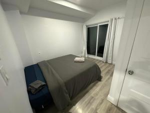um pequeno quarto com uma cama e uma janela em Appartement 2 chambres - 202 em Montreal