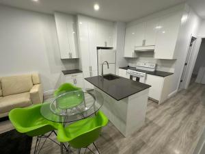 uma cozinha com uma mesa de vidro e cadeiras verdes em Appartement 2 chambres - 202 em Montreal