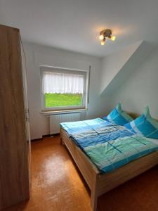 um pequeno quarto com uma cama e uma janela em Ferienhaus Urban mit Garage em Wimbach