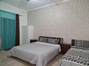 a bedroom with two beds and a wall at Milner Flats in Sliema
