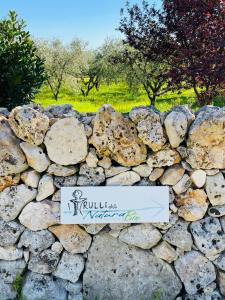 uma parede de pedra com um sinal. em I PapaTrulli Resort - I Trulli della NaturaBio em Martina Franca