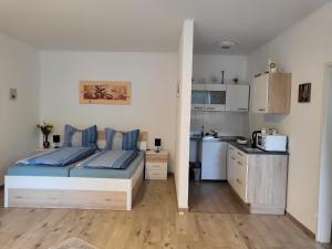 a bedroom with a bed and a small kitchen at Appartement Purzel in Mauerbach