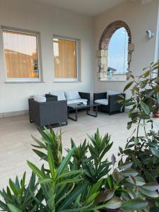 un soggiorno con divani, sedie e piante di Hotel Dorè a Castelnuovo del Garda