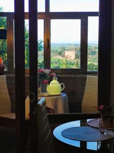 a tea pot sitting on a table in front of a window at Affittacamere Casa Mac & Rose in San Quirico dʼOrcia