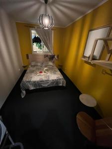a bedroom with a bed in a room with yellow walls at chalet Ti kaz pitaya in Le Tampon