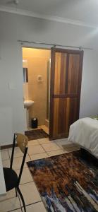 a bedroom with a door leading to a bathroom at Grey lourie Guesthouse in Zeerust