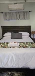 a white bed with a tray on top of it at Grey lourie Guesthouse in Zeerust