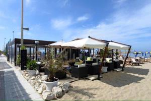 a restaurant on the beach with chairs and umbrellas at SeeConero home in Ancona