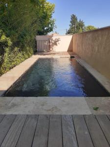 una piscina de agua junto a una terraza de madera en Chambre de charme, en Cuers