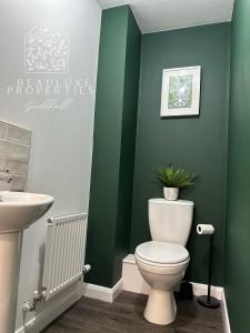 a bathroom with a toilet and a sink at Guildhall - Beauluxe Properties large property - 3 bedroom - 4 beds - sleeps upto 6 people in Church Gresley