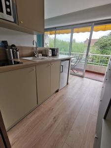a kitchen with wooden floors and a view of a balcony at Studio Sunset Biarritz in Biarritz