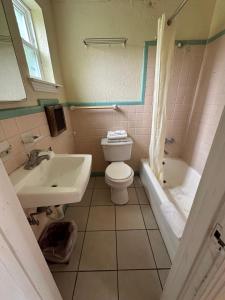 a bathroom with a toilet and a sink and a tub at Sands Motel in San Antonio