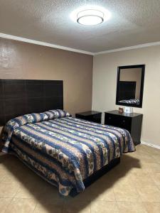 a bedroom with a bed and a flat screen tv at Sands Motel in San Antonio