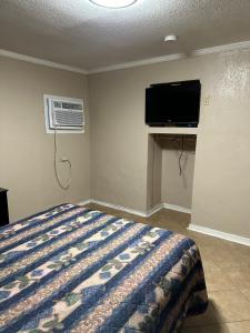 a bedroom with a bed and a air conditioner at Sands Motel in San Antonio