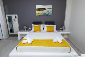 a bedroom with a large white bed with yellow pillows at Guest House Narta in Vlorë