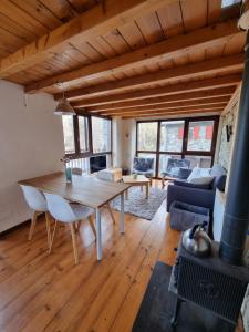 sala de estar con mesa de madera y chimenea en Orri de Planès en Planès
