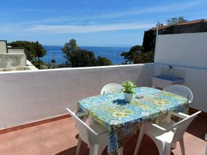 uma mesa e cadeiras numa varanda com vista para o oceano em A Casicedda em Lipari