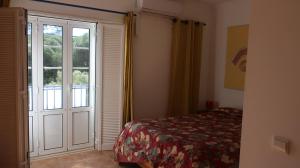 um quarto com uma cama e uma porta com uma janela em Casa Bambu, Paraiso na Terra em Praia Verde