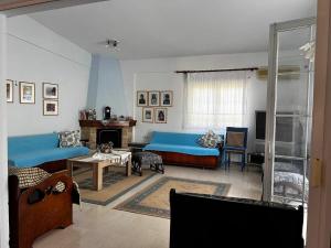 a living room with blue couches and a table at Anna's House in Kokkino Nero