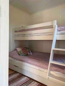 a bedroom with two bunk beds in a house at Stuga i Björkäng med havsutsikt! in Tvååker