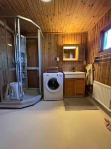 a bathroom with a washing machine and a shower at Stuga i Björkäng med havsutsikt! in Tvååker