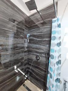 a bathroom with a shower with a glass wall at Godard Apartments in Vlorë