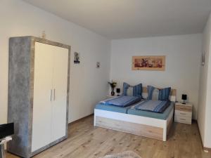 a bedroom with a bed with blue pillows and a mirror at Appartement Purzel in Mauerbach