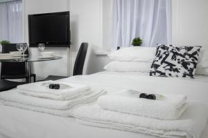 a room with a bed with towels and a table at BARTON BEACHSIDE APARTMENTS - Free Parking, Modern Chic, Central Beach Location, Some Sea Views - Families Couples or Over 23 years in Blackpool